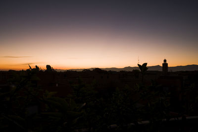 Silhouette people against clear sky during sunset