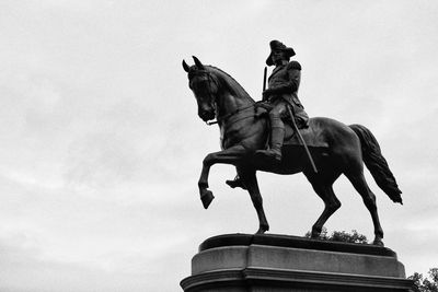 Low angle view of horse statue against sky