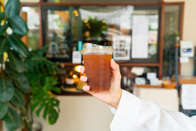 Close-up of hand holding beer glass