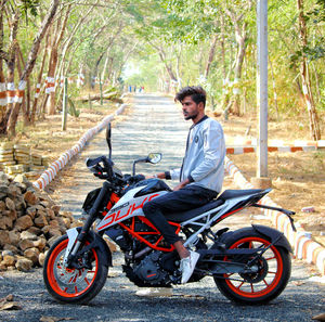 Full length portrait of a young man riding motorcycle