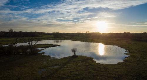 Scenic view of lake against sky at sunset