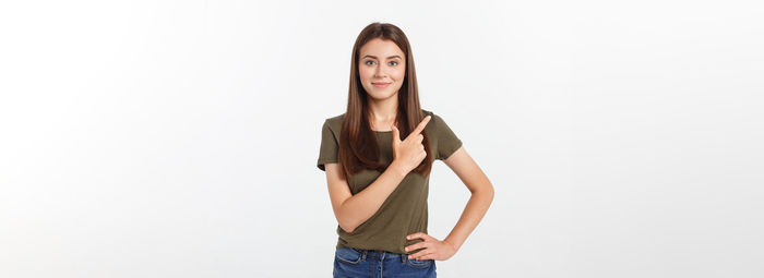 Portrait of young woman standing against white background