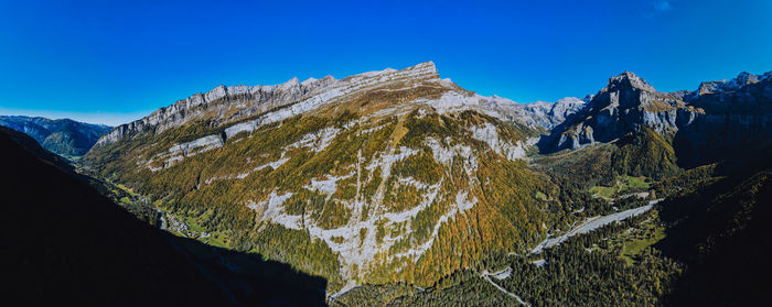 Scenic view of snowcapped mountains against clear blue sky