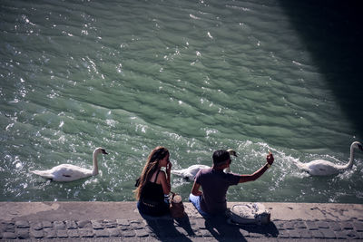 High angle view of couple sitting at riverbank