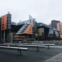 Empty road by buildings against clear sky