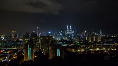 Illuminated cityscape against sky at night