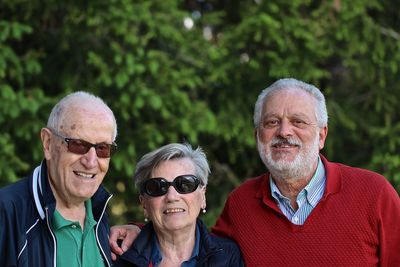 Portrait of smiling friends standing against plants