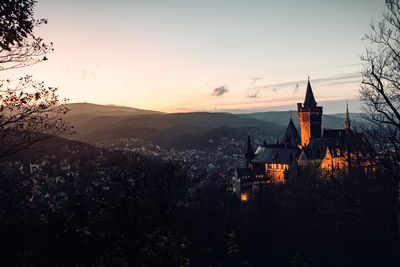 Illuminated buildings against sky during sunset