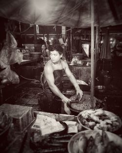 Portrait of young woman sitting at market