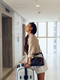 Side view of young woman standing in gym