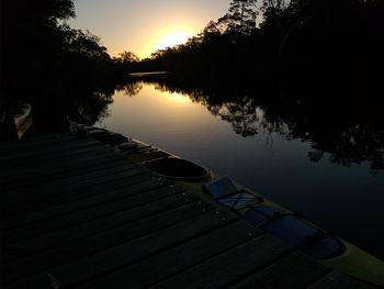 Pier over lake against sky during sunset