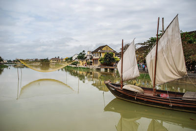 Boats moored in lake against sky