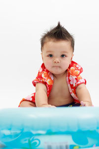 Cute baby boy with inflatable ring against white background