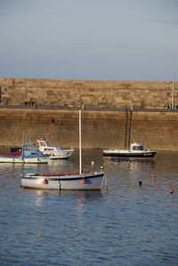 Boats moored in sea against clear sky