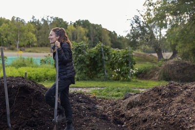 Smiling woman digging in garden