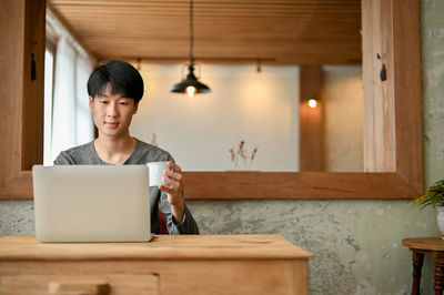 Young man using laptop at home