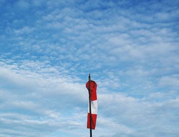 Low angle view of pole against cloudy sky