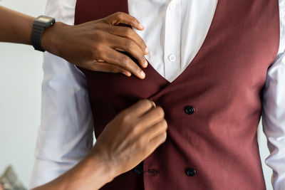 Midsection of burgundy suit fitting with white shirt