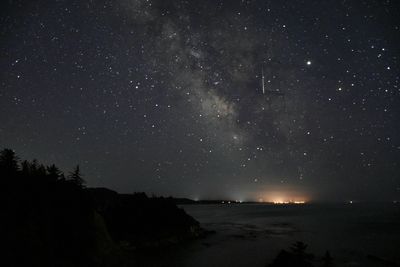 Scenic view of sea against star field at night