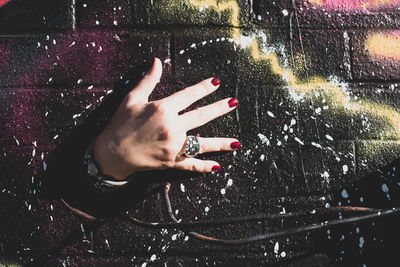 Close-up of woman hand on red wall