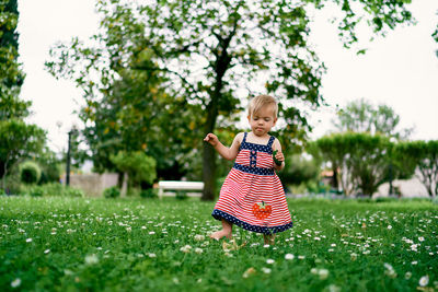 Cute girl walking on grass at park