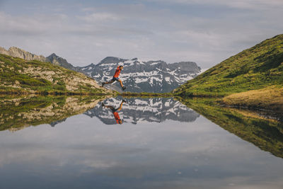 Scenic view of lake by mountain against sky