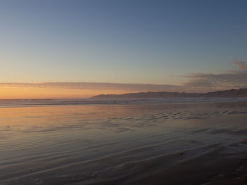 Scenic view of sea against clear sky during sunset