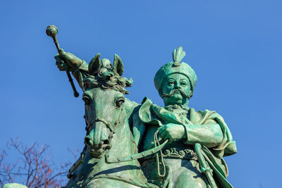 Low angle view of statue against clear blue sky