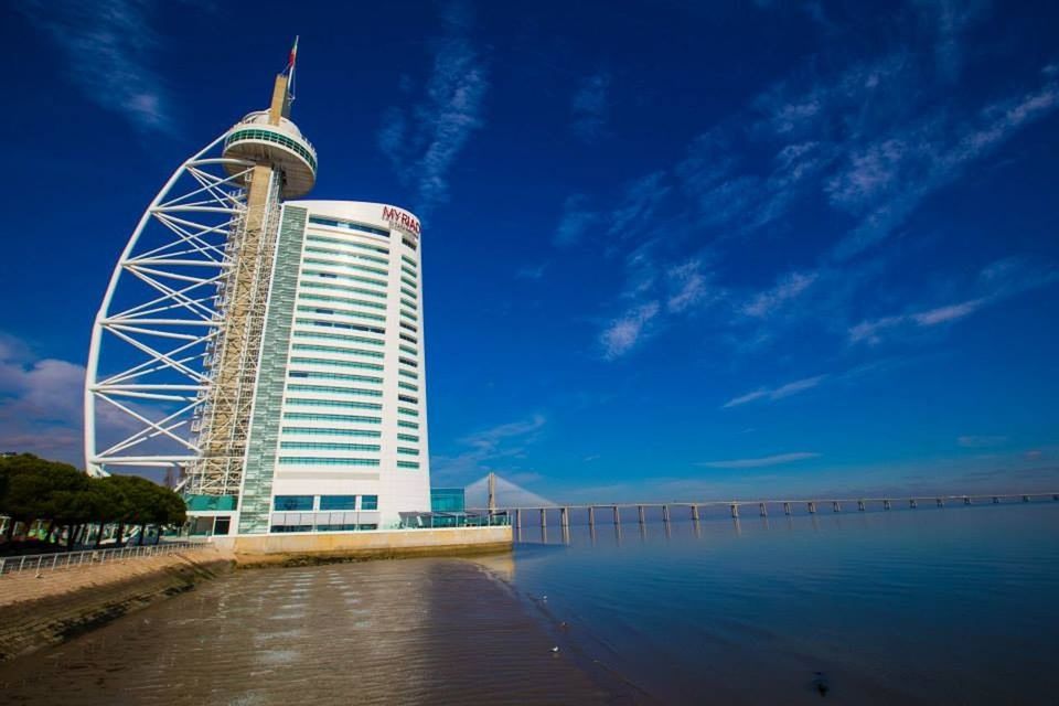 architecture, built structure, building exterior, water, sea, sky, blue, tower, waterfront, lighthouse, tall - high, outdoors, no people, cloud - sky, city, day, the way forward, river, cloud, travel destinations