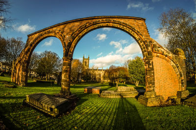 Arch wall in cemetery at stoke minster against sky