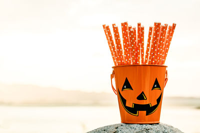 Close-up of pumpkin on cross against sky