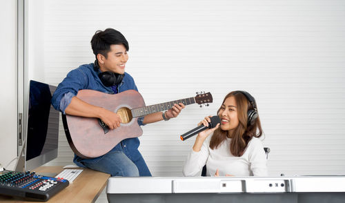 Young couple playing guitar