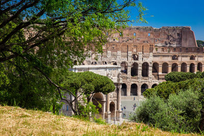 Tourists visiting the famous colosseum and the arch of constantine in rome
