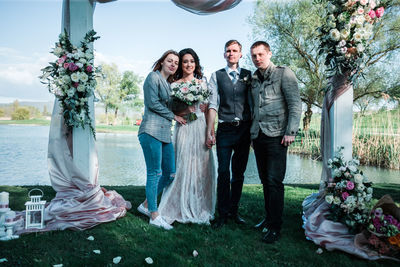 Portrait of friends standing by potted plants