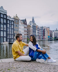 Friends sitting on a building in city