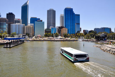 Boats in river with city in background