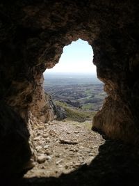 Scenic view of rock formation seen through cave