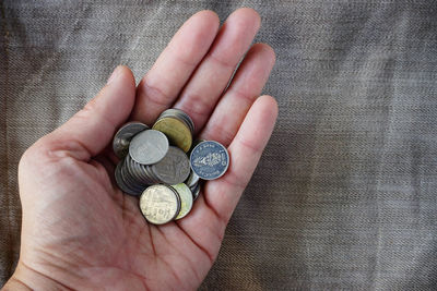 High angle view of hand holding coins