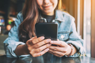 Midsection of woman using mobile phone