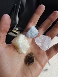 Close-up of hand holding various crystals