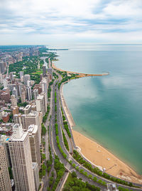 High angle view of buildings by sea against sky