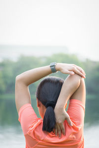 Rear view of woman with arms raised in water