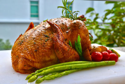 Close-up of roast chicken in cutting board