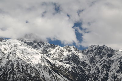 Low angle view of snowcapped mountains against sky