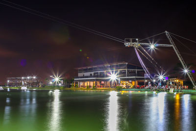 Illuminated bridge over river at night