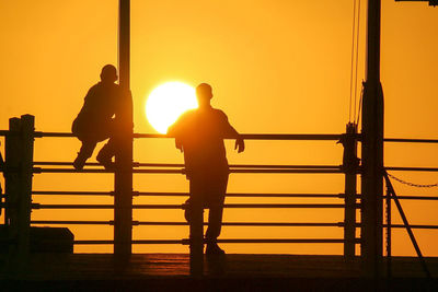 Silhouette people against sunset