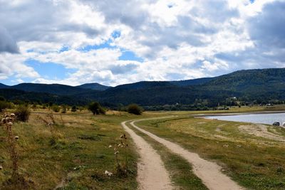 Road by landscape against sky