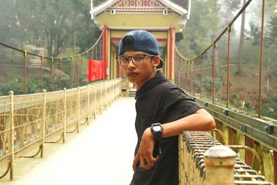 Portrait of man standing on footbridge