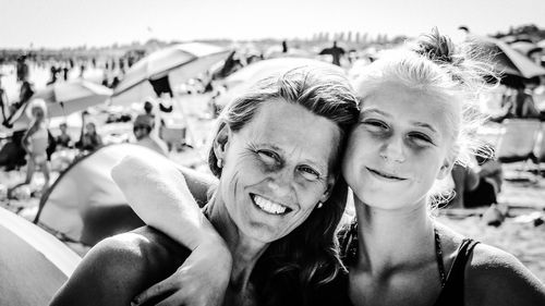 Close-up portrait of happy mature woman with daughter at beach