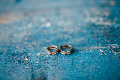 Close-up of wedding rings on blue surface